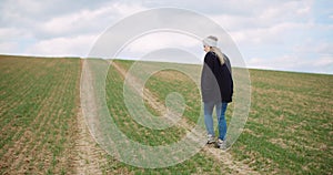 Agriculture - female farmer walking on agricultural field