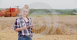 Agriculture female farmer walking in wheat field with digital tablet