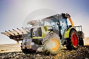 Agriculture industry machinery. Combine harvester and tractor with trailer unloading harvest. Farmer working details