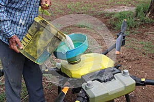 Agriculture man pouring chemicals used in agriculture Put it in a tank attached to the drone