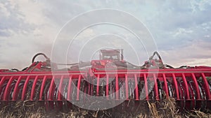 Agriculture. tractor plows a field of black soil against the background of blue clouds. agriculture business industry