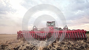 Agriculture. tractor plows a field of black soil against the background of blue clouds. agriculture business industry