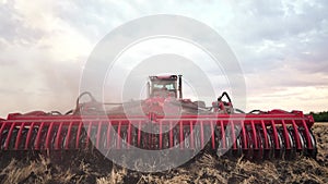 Agriculture. tractor plows a field of black soil against the background of blue clouds. agriculture business industry