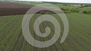 agriculture. tractor plows a green field start of agricultural work. aerial top view business agriculture concept