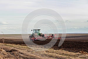 Agriculture,tractor preparing land with seedbed cultivator as part of pre seeding activities in early spring season of