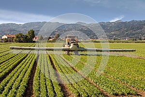 Agriculture, tractor spraying pesticides on field farm photo