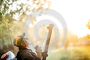 Agriculture worker farmer spraying organic pesticides on fruit growing plantation