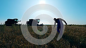 Agriculturer, farmer is walking towards the combine vehicles