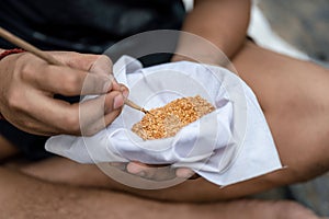 Agriculturist using stick to pick vegetable seeds