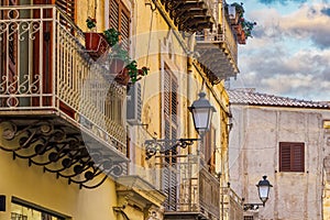 Agrigento traditional architecture houses with iron balconies, lanterns and decayed facade in Sicily, Italy