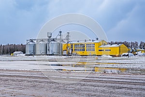 agro-industrial complex with silos and a seed cleaning and drying line for grain storage in snow of winter field