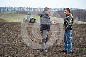 agronomist and farmer checks the soil moisture before sowing cereals