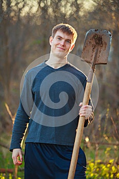 Agronomist handsome strong man with shovel on background of flo
