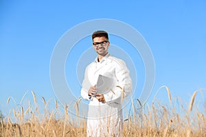 Agronomist with laptop in wheat field. Cereal  crop