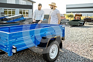 Agronomist with salesman choosing truck trailer at the shop