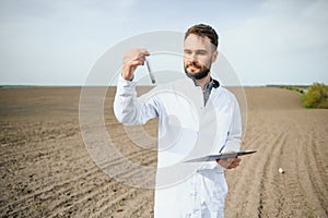 Agronomist studying samples of soil in field