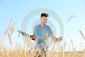 Agronomist with tablet in field. Cereal grain crop