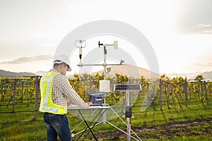 Agronomist using tablet computer collect data with meteorological instrument to measure the wind speed, temperature and humidity