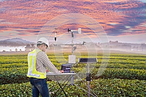 .Agronomist using tablet computer collect data with meteorological instrument to measure the wind speed, temperature and humidity photo