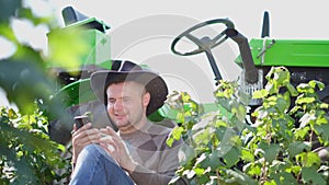 Agronomist using tablet modern technologies in agriculture. The farmer sits in front of the tractor