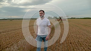 Agronomist in white t-shirt and jeans walking in wheat field.