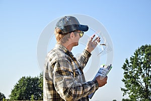 Agronomy specialist examining ears of wheat at grain field at sunrise