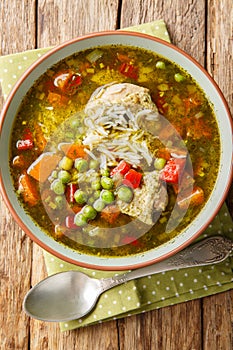 Aguadito de Pollo Chicken and Cilantro Soup closeup on the bowl. Vertical top view photo