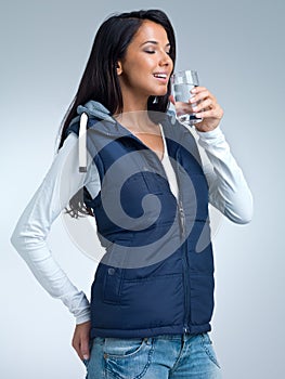 Ahhh... So refreshing. A studio shot of a beautiful woman drinking a glass of water.