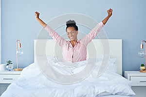 Ahhh that small little nap felt great. a happy young woman waking up in bed in the morning.