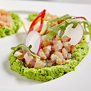 Ahi Tuna Seviche with Radish Slices and Rucola on White Plate photo