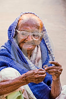 Close up of old aged poor lady bagging in front of mosque