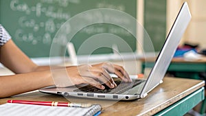 AI generated close up of fingers typing on a laptop in a class