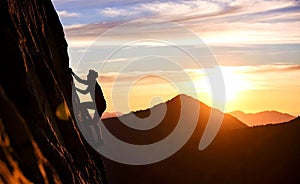 Rock Climber Silhouette Ascending Mountain Cliff During Sunset