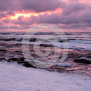 AI-generated illustration of ocean waves and a snow-covered shore at sunset with purple clouds above