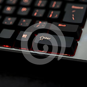 AI Generated Image of a Black Computer Keyboard with a Glowing Orange Enter Key