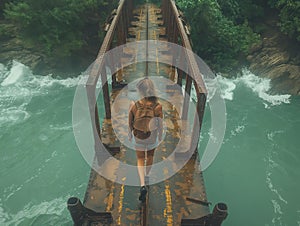 AI generated image,A man walking across a rope bridge in the mountain, in the style of dark yellow and bronze, artistic reportage,