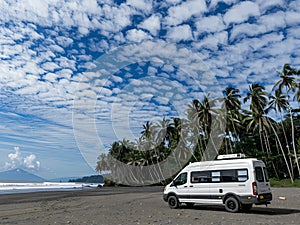 AI-Generated image of A white van is parked on a beach next to palm trees