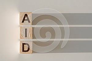 AID word written on wood block. Concept. Help, assistance, support