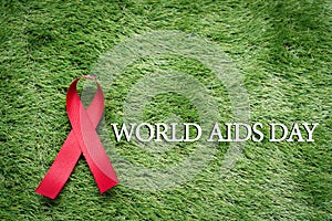 Aids Awareness Sign Red Ribbon, the fight against AIDS sign on green grass