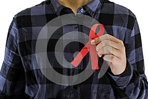 AIDS concept. Woman holding red ribbon in hands close u
