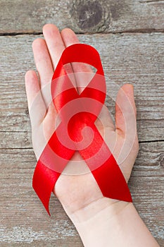 Aids red ribbon on woman`s hand support for World aids day and n