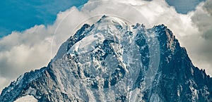 Aiguille Verte in close-up with snow topped mountain and clouds in the background