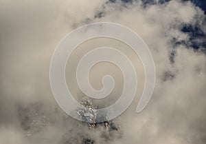 Aiguilles mountain peaks through clouds and blue sky. Chamonix, France