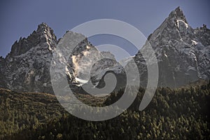 Aiguilles mountain range peaks and green forest. Chamonix, France