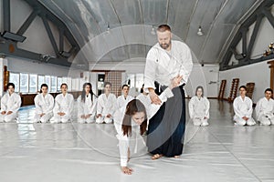 Aikido instructor teaching teenager fighters during group training in gym