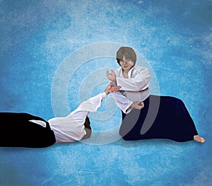 An Aikido Master performs a technique on a blue sky background