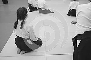 Aikido training participants sit on a mat