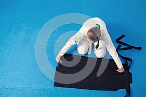 An aikidoka girl folding hakama for Aikido training