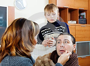 Ailing man surrounded by caring wife and son