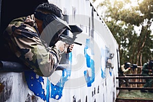 Aim, gun or people in a paintball shooting game with fast action on a fun battlefield on holiday. Man on mission